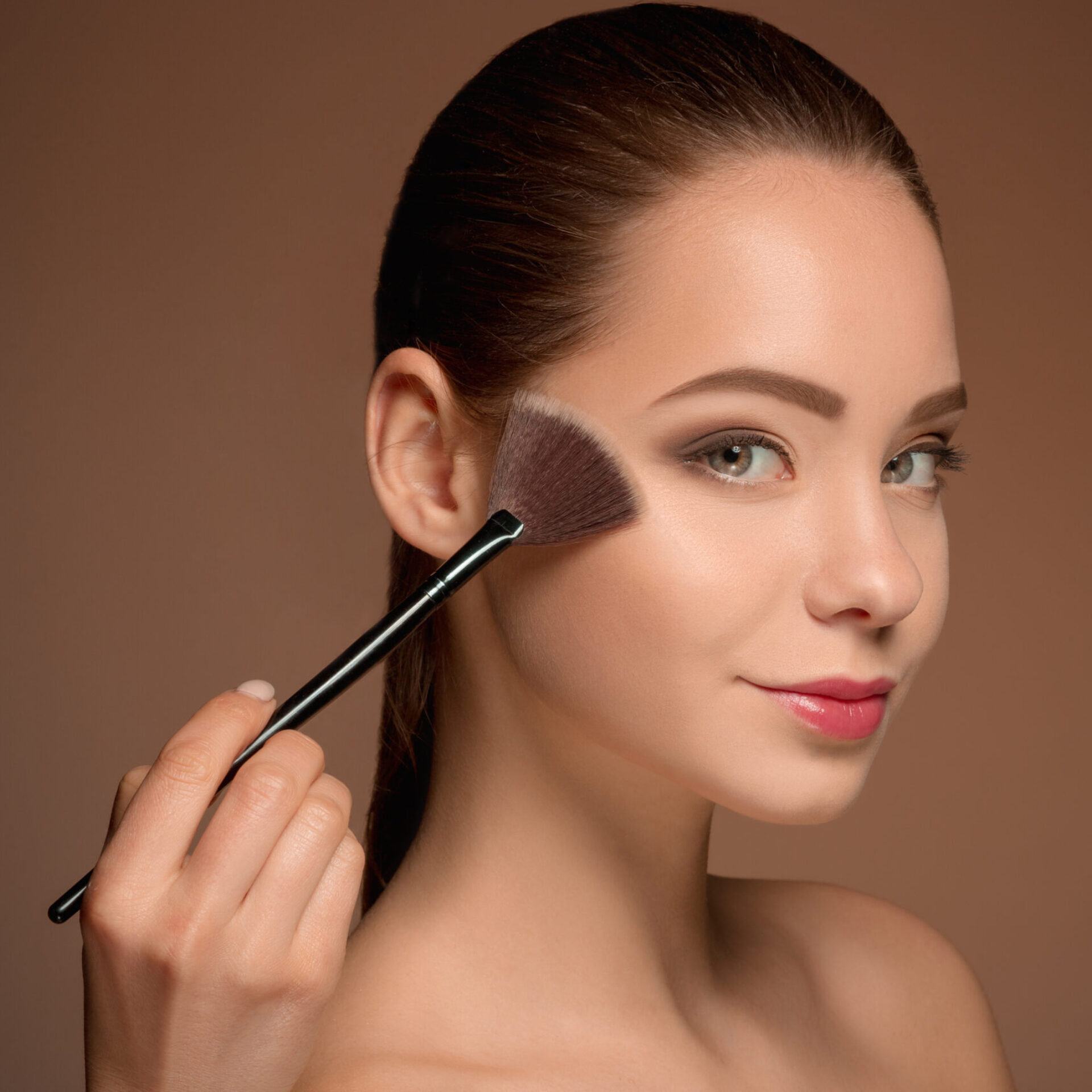 Beauty Girl with Makeup Brush. Perfect Skin. Applying Makeup